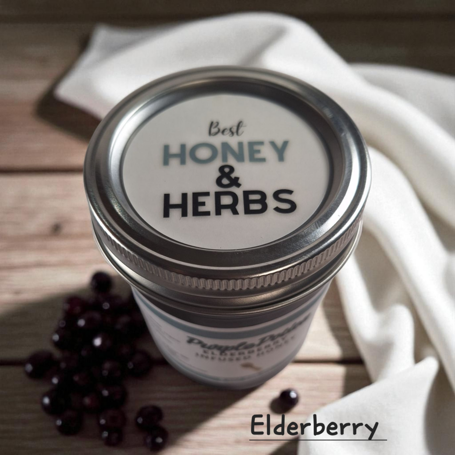 Top view of 8 oz half-pint jar of raw Elderberry Infused Honey on a wooden surface, antioxidant-rich herbal sweetener for tea, baking, and wellness tonics.