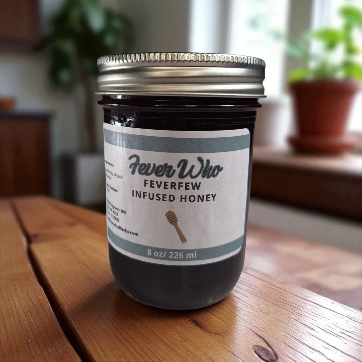 8 oz half-pint jar of raw Feverfew Infused Honey on a rustic wooden surface, herbal sweetener for tea, baking, and traditional herbal uses.