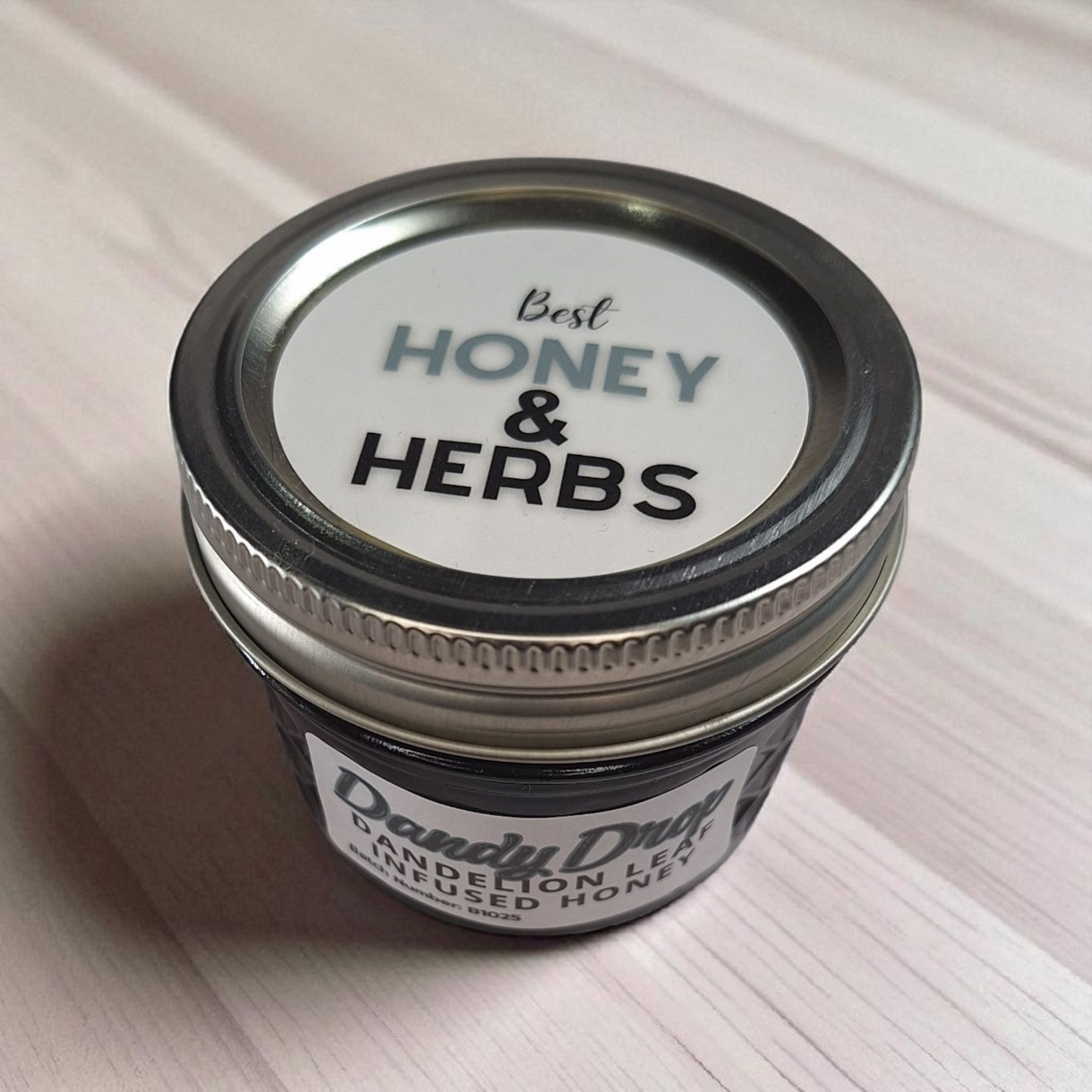 Top-view 4 oz Dandelion Leaf Infused Honey resting on natural wood; herbal honey for herbal tea, salad dressings, and baking.