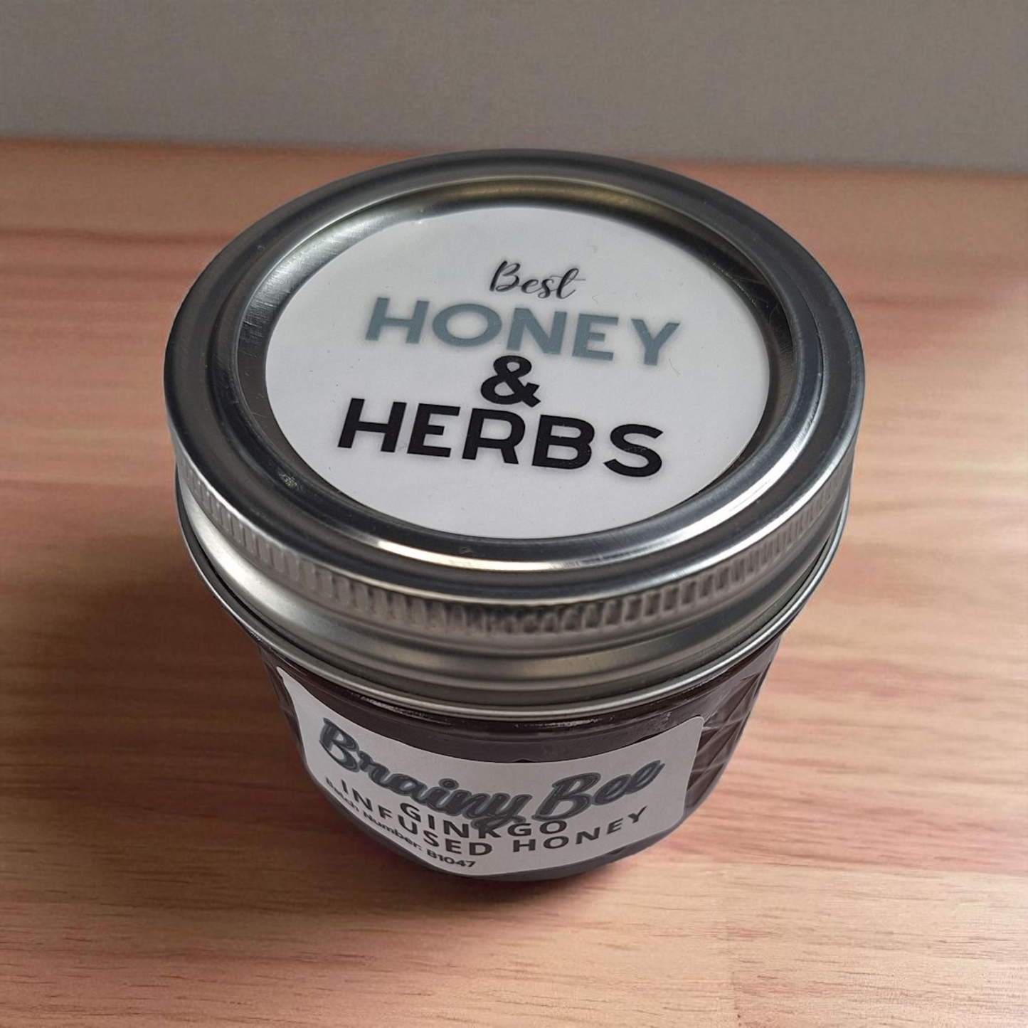 Bird’s-eye 4 oz Ginkgo Infused Honey on a wooden surface; small-batch herbal honey for tea, smoothies, and breakfast bowls.