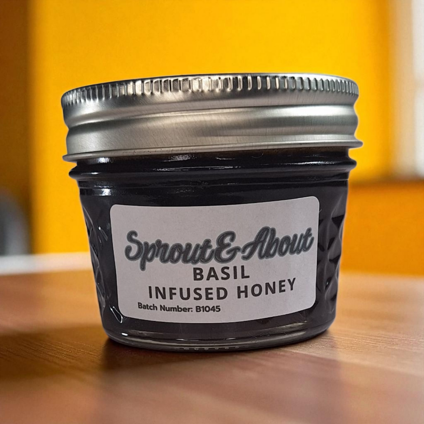 4 oz jar of raw Basil Infused Honey on a wooden surface, small-batch herbal honey perfect for drizzling on bread, salads, or cheese.