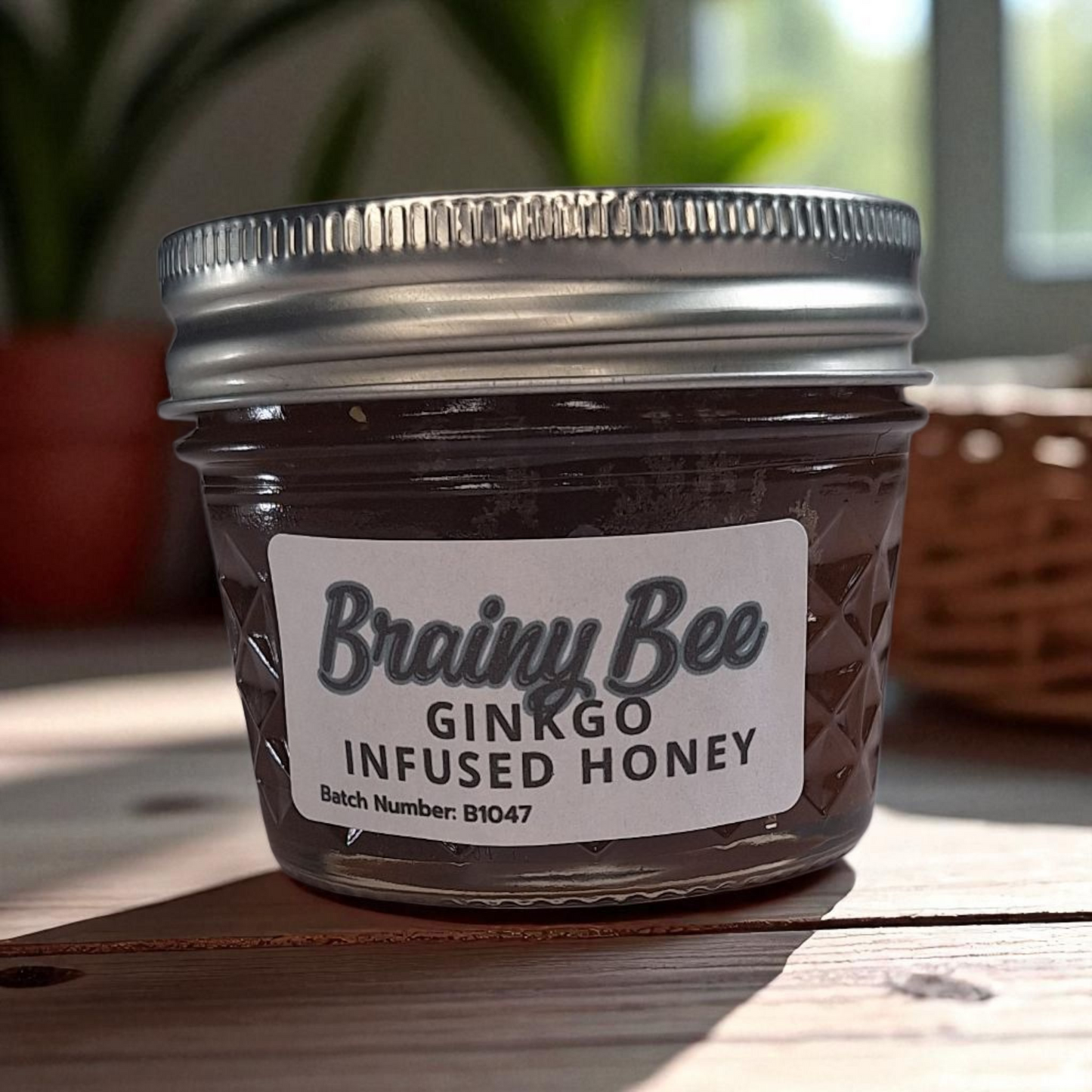 4 oz jar of raw Ginkgo Infused Honey on a wooden surface, small-batch herbal honey for tea, memory support, and healthy recipes.