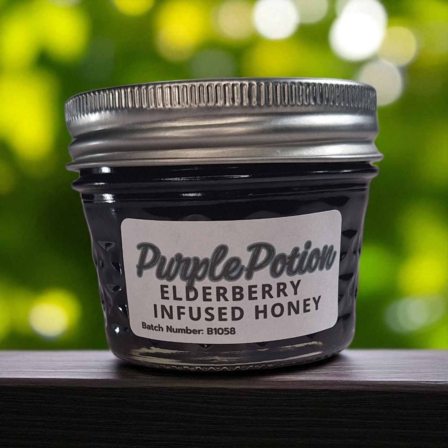 4 oz jar of raw Elderberry Infused Honey on a wooden surface, antioxidant-rich herbal sweetener for tea, baking, and wellness tonics.