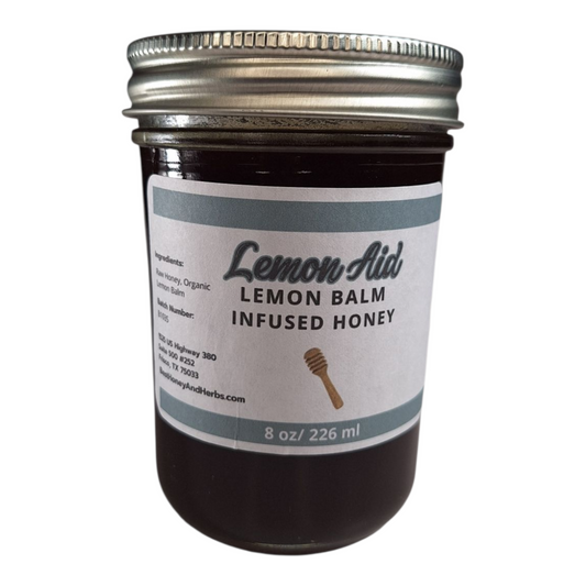 8 oz jar of raw Lemon Balm Infused Honey, citrusy herbal sweetener for tea, baking, and calming recipes, on a plain white background.