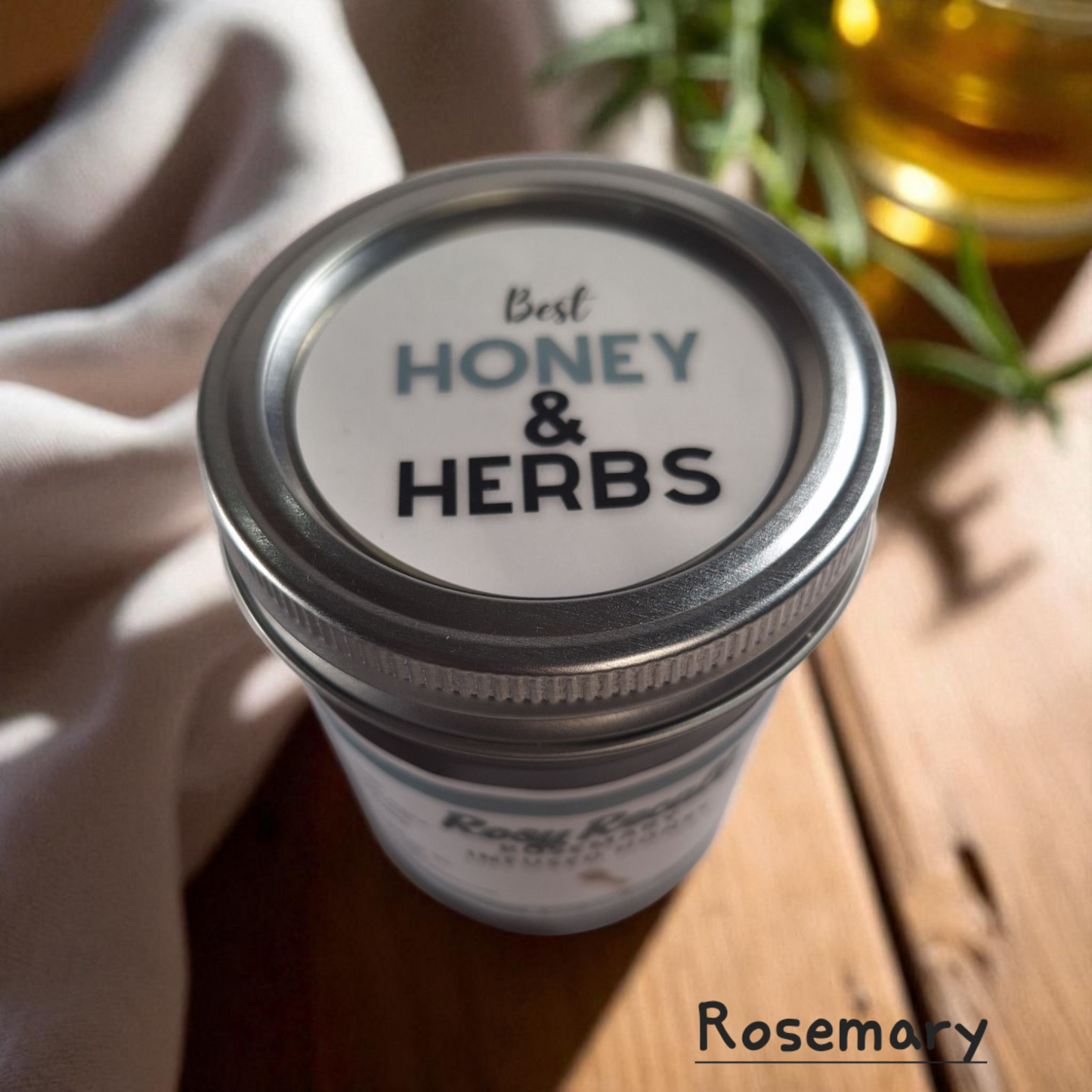 Top view of 8 oz half-pint jar of raw Rosemary Infused Honey on a wooden surface, savory herbal sweetener for meats, bread, and roasted vegetables.
