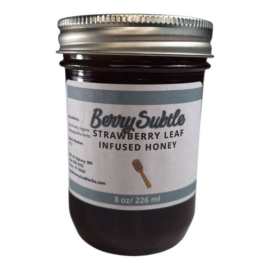 8 oz jar of raw Strawberry Leaf Infused Honey, mild herbal sweetener for tea, baking, and healthy recipes, on a plain white background.