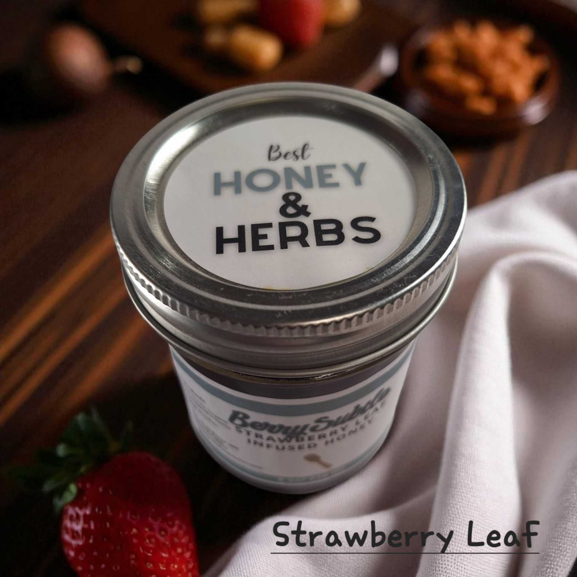 Top view of 8 oz half-pint jar of raw Strawberry Leaf Infused Honey on a rustic wooden surface, mild herbal sweetener for tea, baking, and healthy recipes.