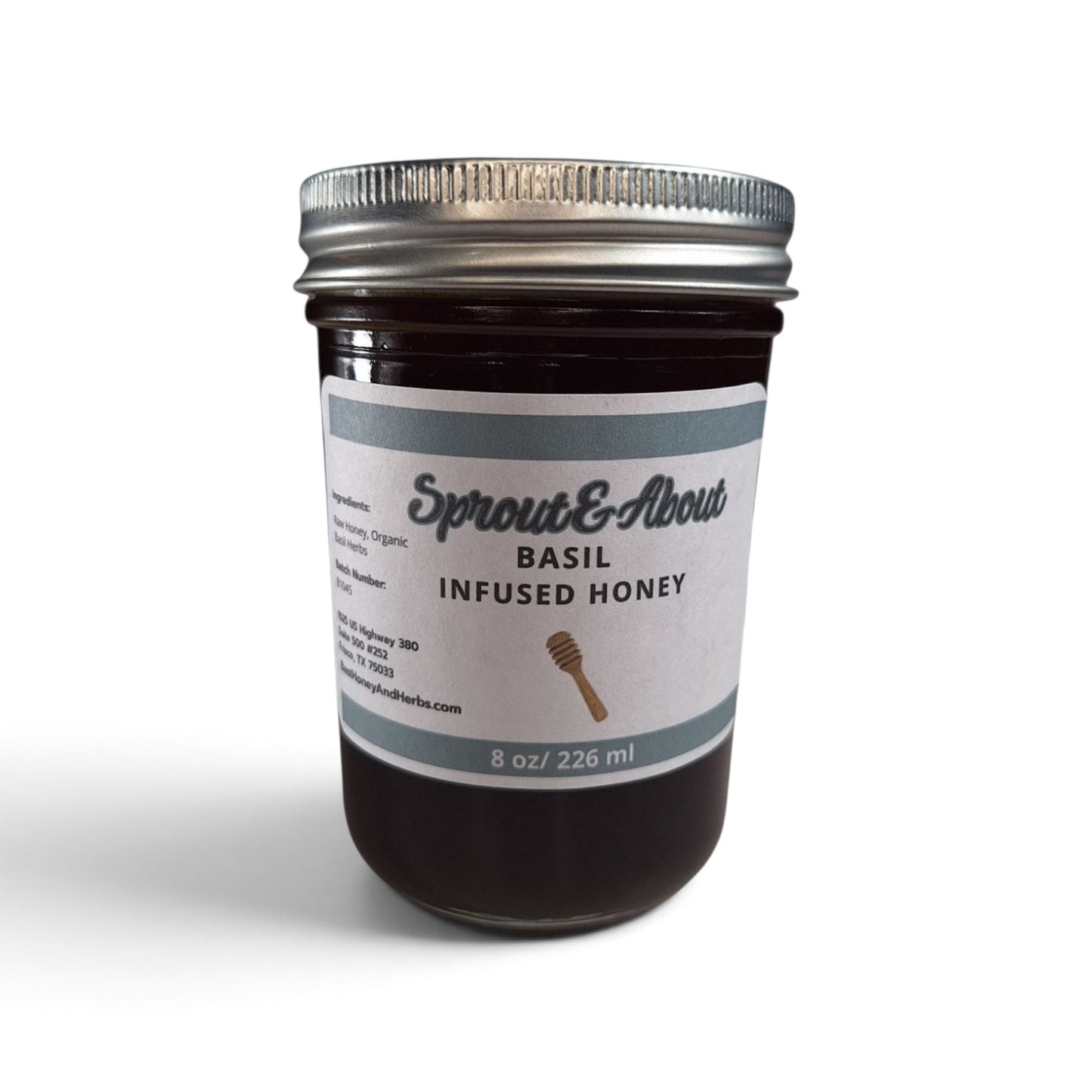 Basil infused raw honey in a half pint mason jar with a silver lid.