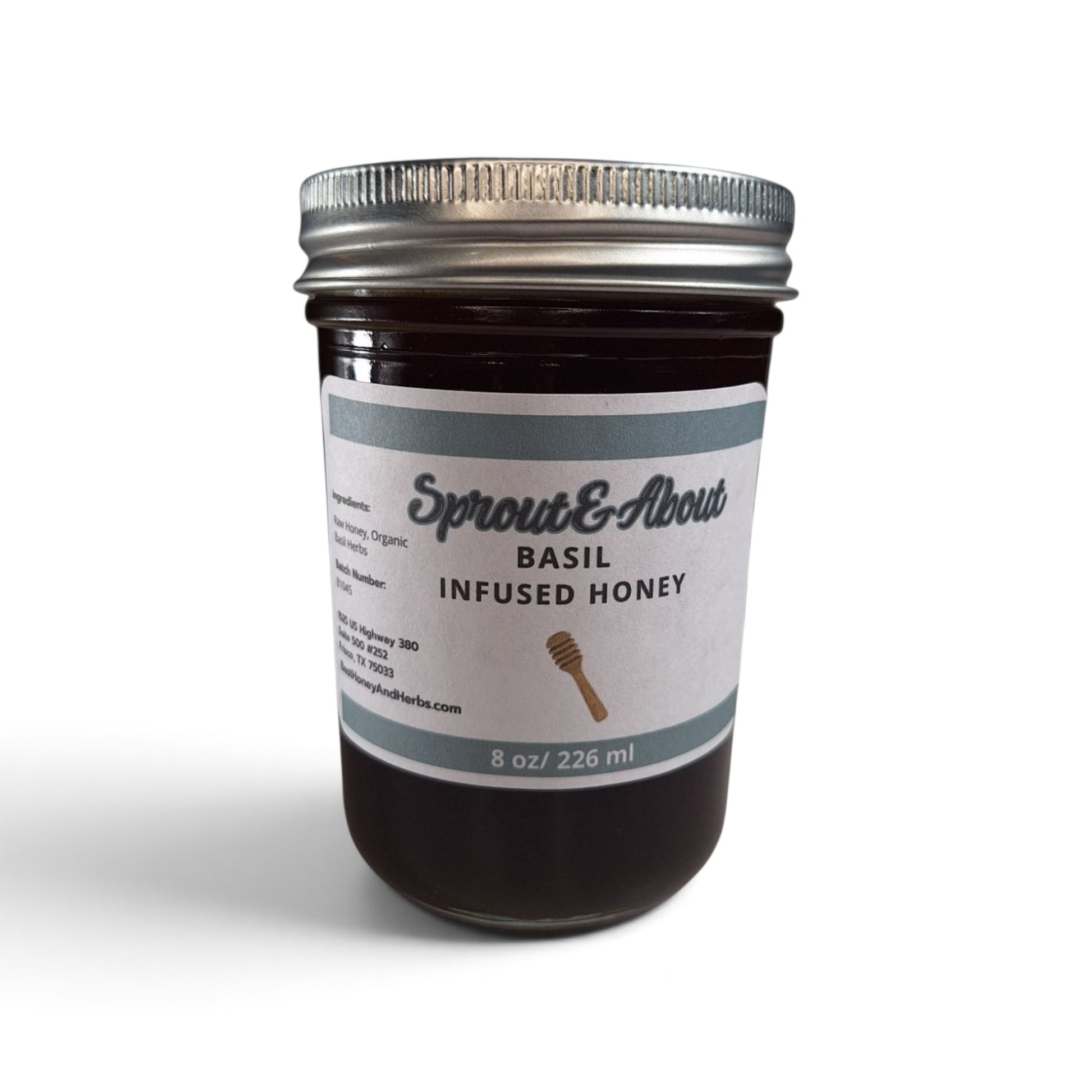 Basil infused raw honey in a half pint mason jar with a silver lid.