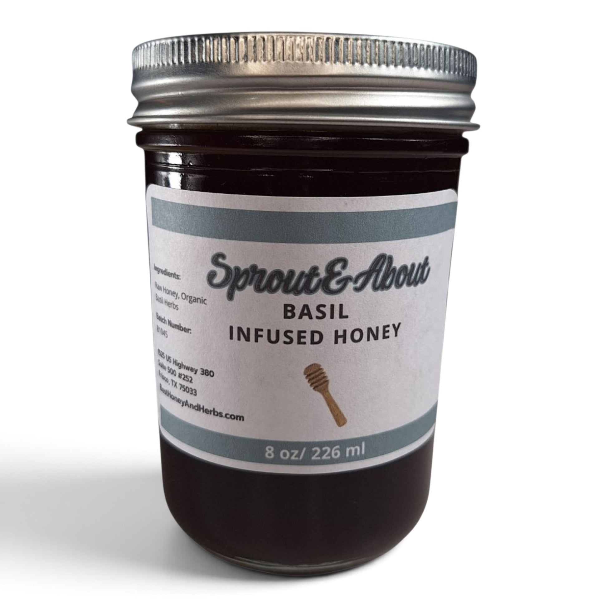  Basil infused raw honey in a half pint glass jar with a silver lid.
