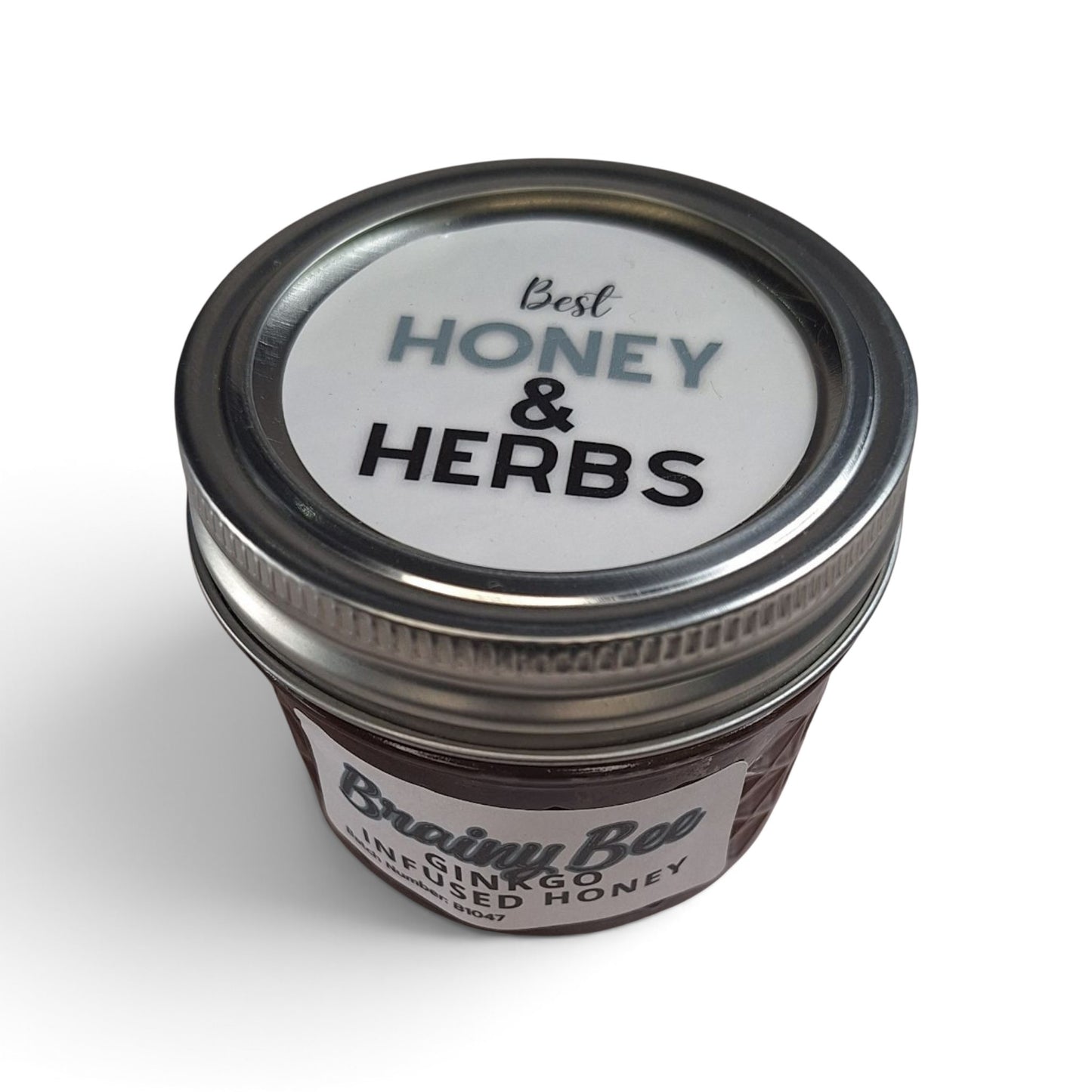  Ginkgo infused raw honey in a small glass jar with a silver metal lid.