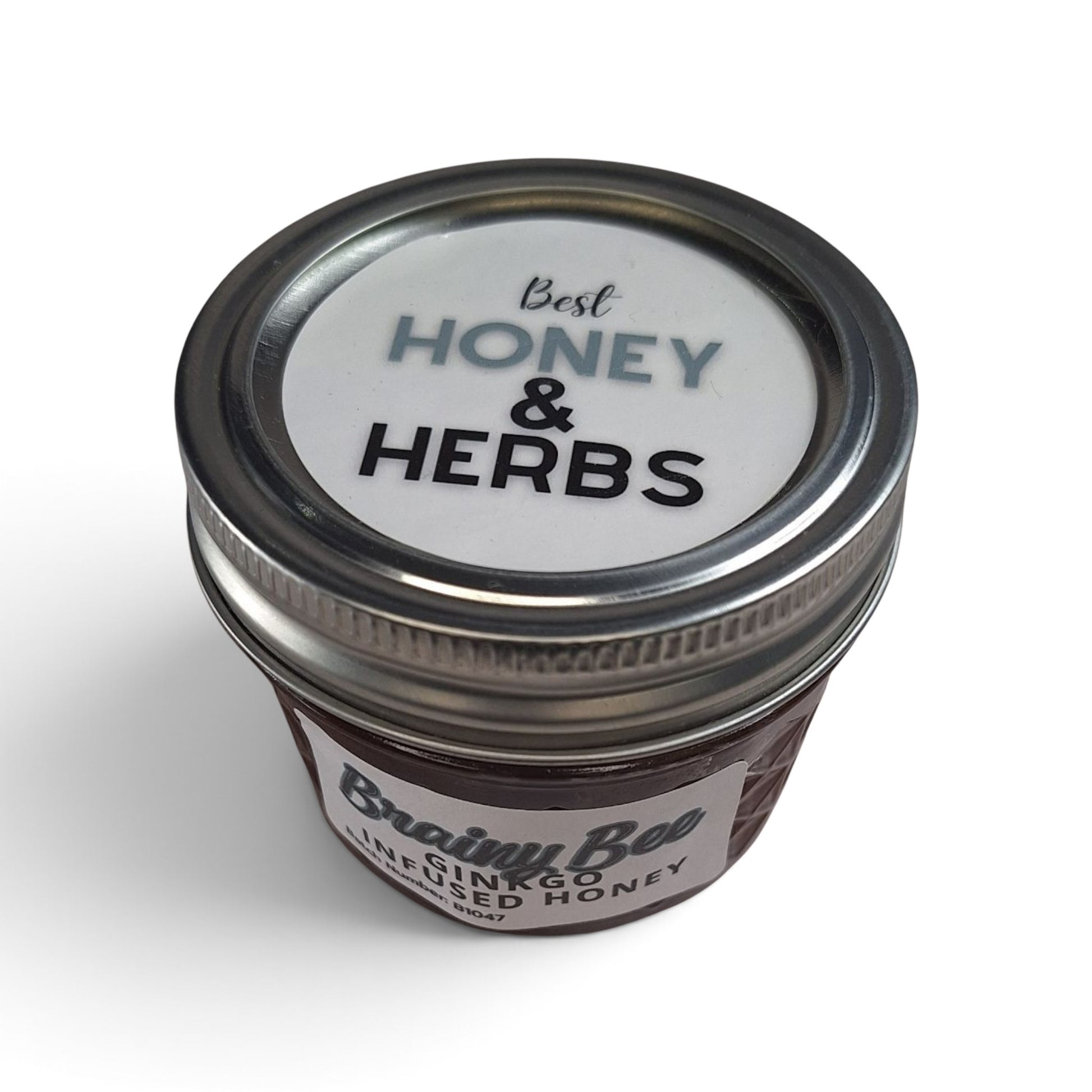  Ginkgo infused raw honey in a small glass jar with a silver metal lid.