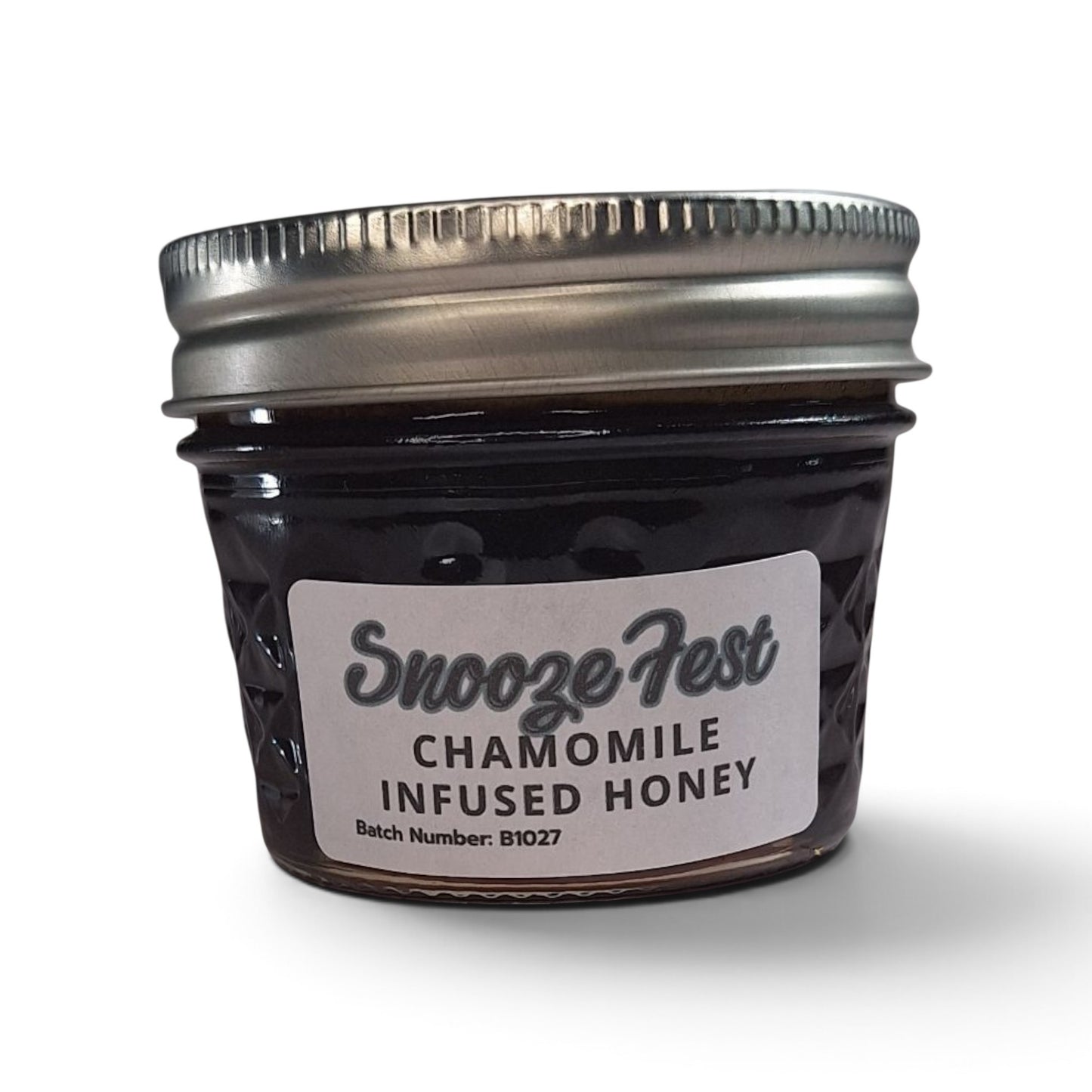  Chamomile infused raw honey in a small glass jar with a silver lid.