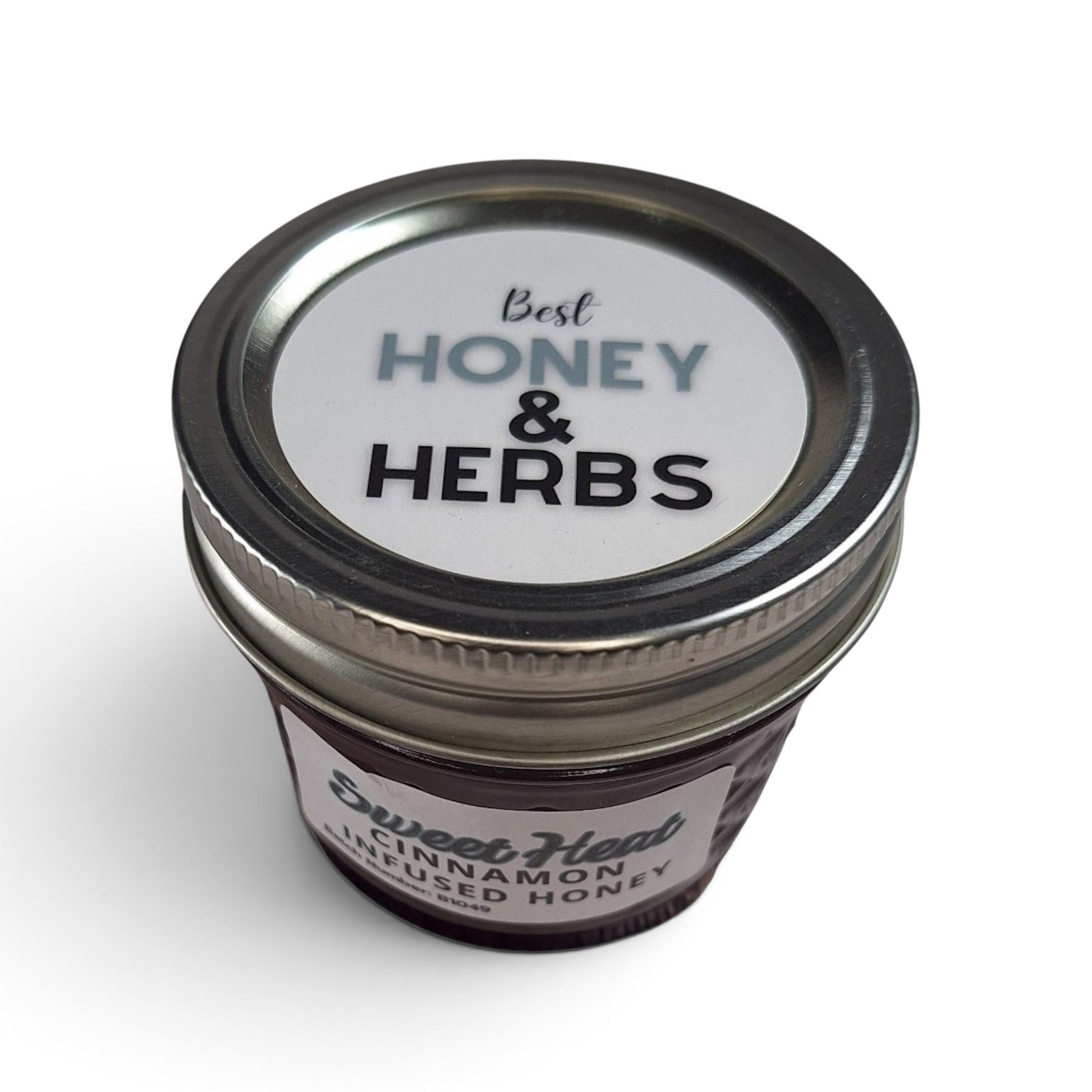  Cinnamon infused raw honey in a quarter pint glass jar with a metal lid.