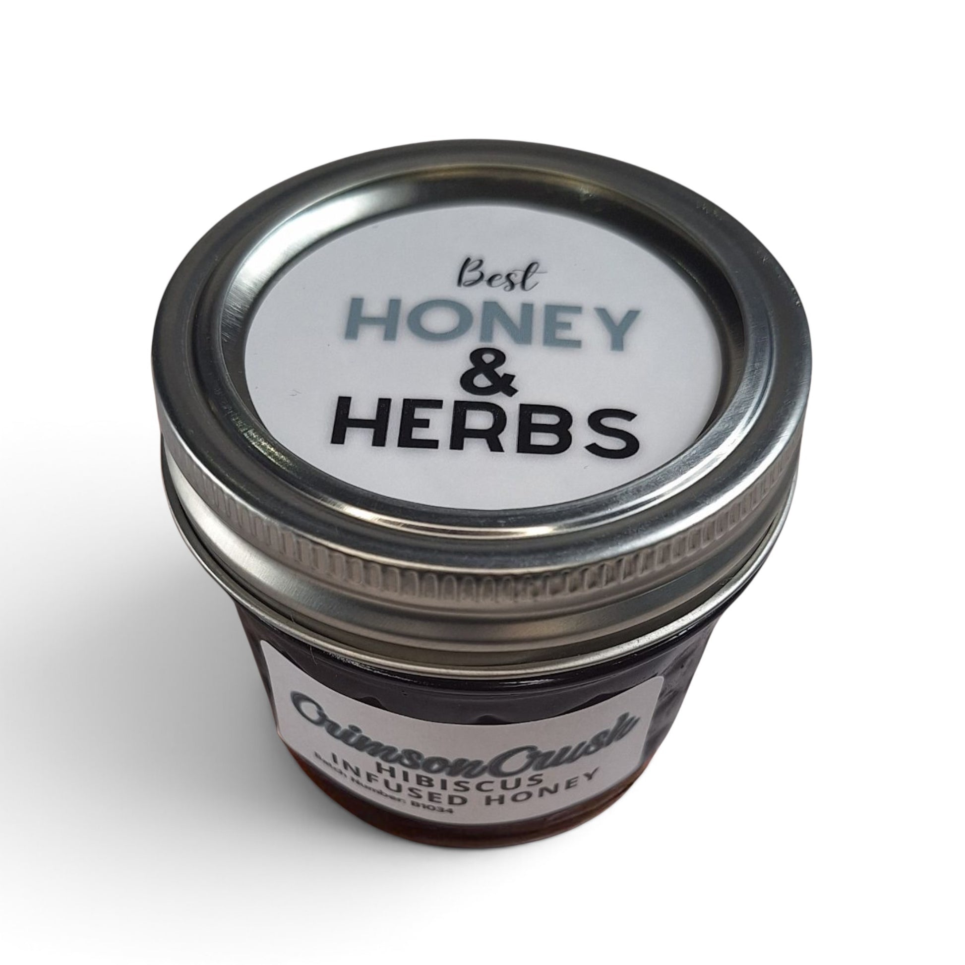  Hibiscus infused  honey in a small glass jar with a metal lid.