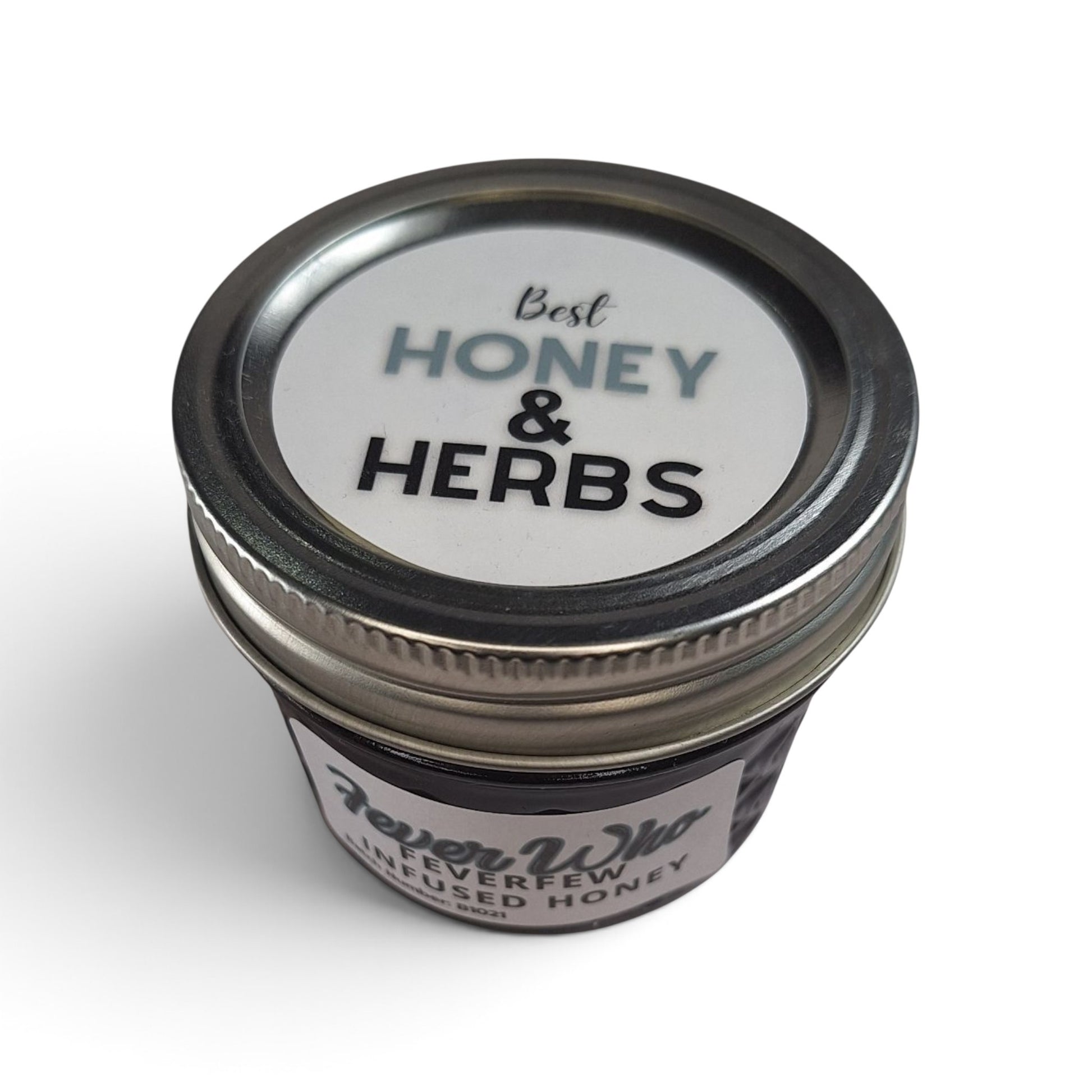  Feverfew infused raw honey in a small glass jar with a metal lid, top-down view.