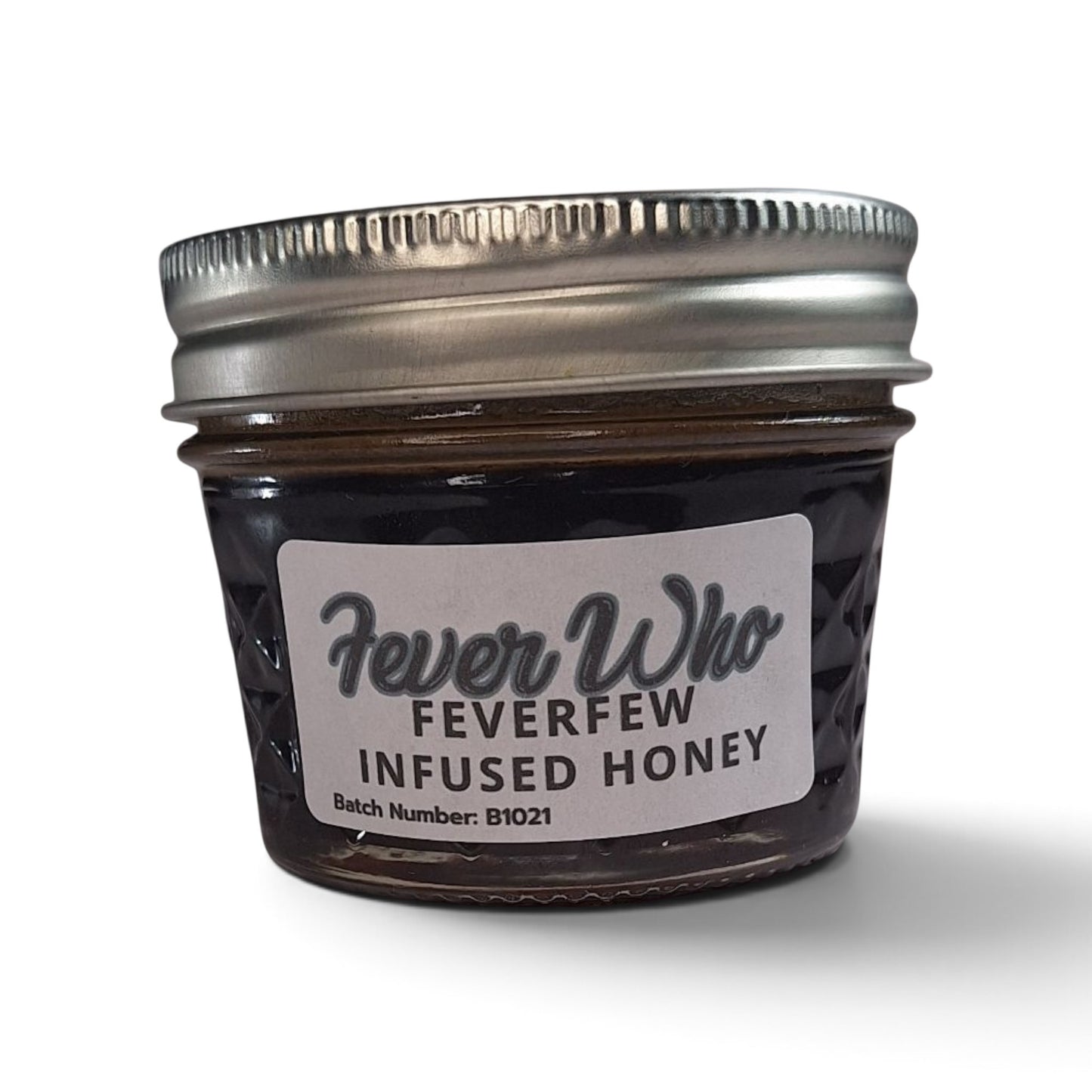  Raw honey infused with organic feverfew in a small glass jar with a silver lid.