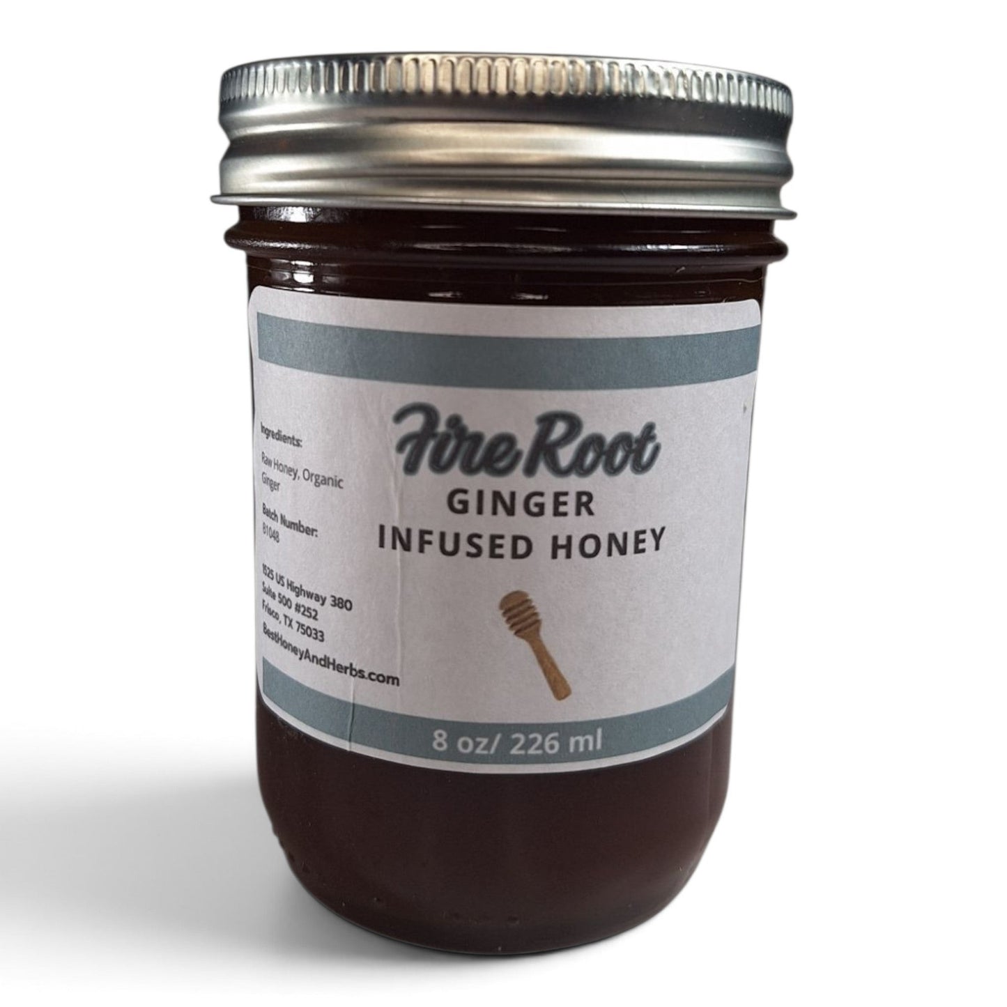 Ginger infused raw honey in a half pint mason jar with a metal lid and white label.
