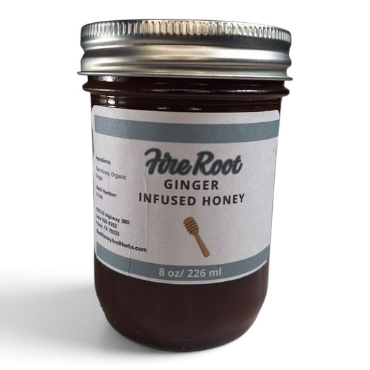 Ginger infused raw honey in a half pint mason jar with a metal lid and white label.