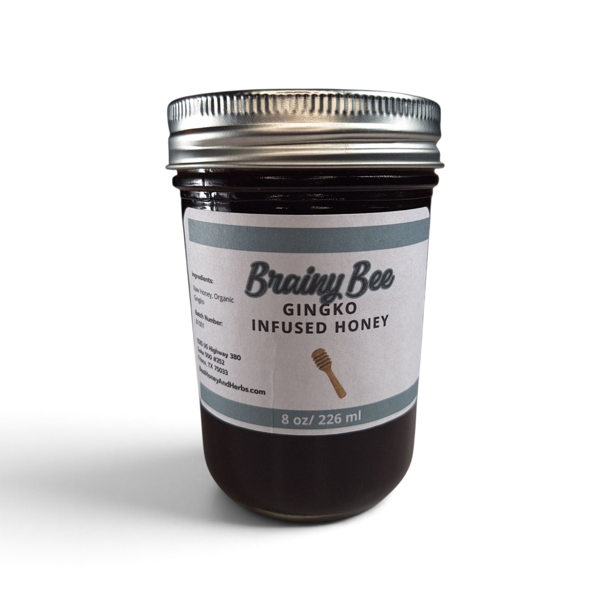 Ginkgo infused raw honey in a glass jar with a silver lid on a white background.