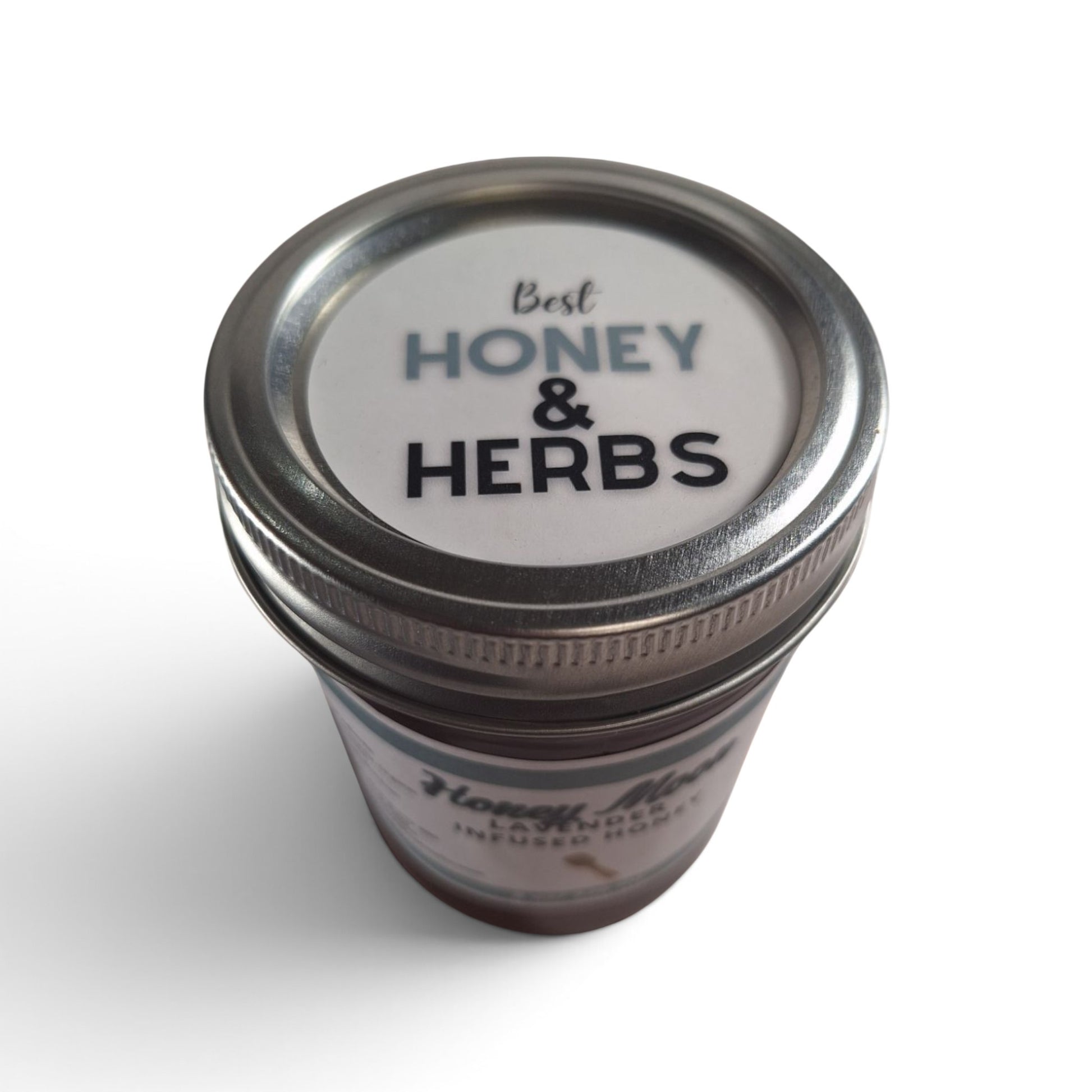  lavender honey in a glass jar with a metal lid, top-down view.