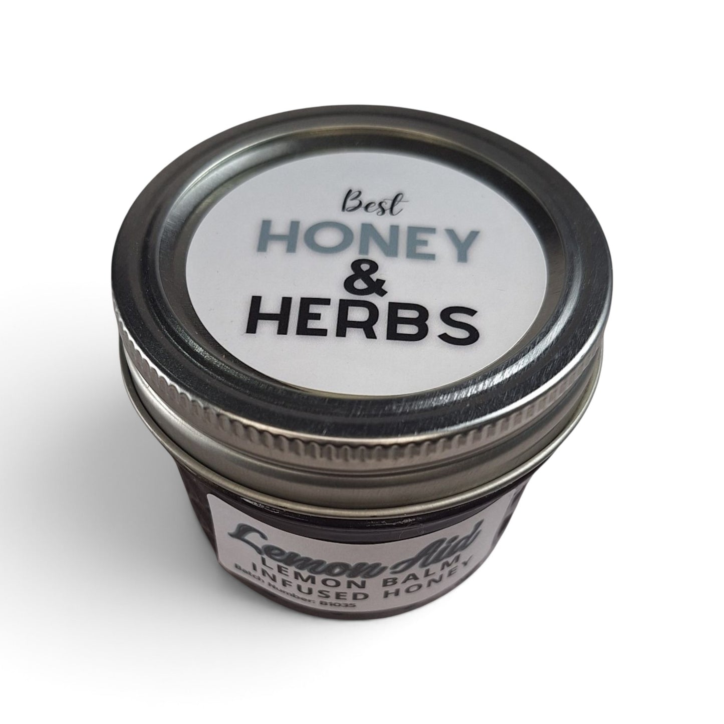 Raw honey infused with organic lemon balm in a small glass jar with a metal lid.