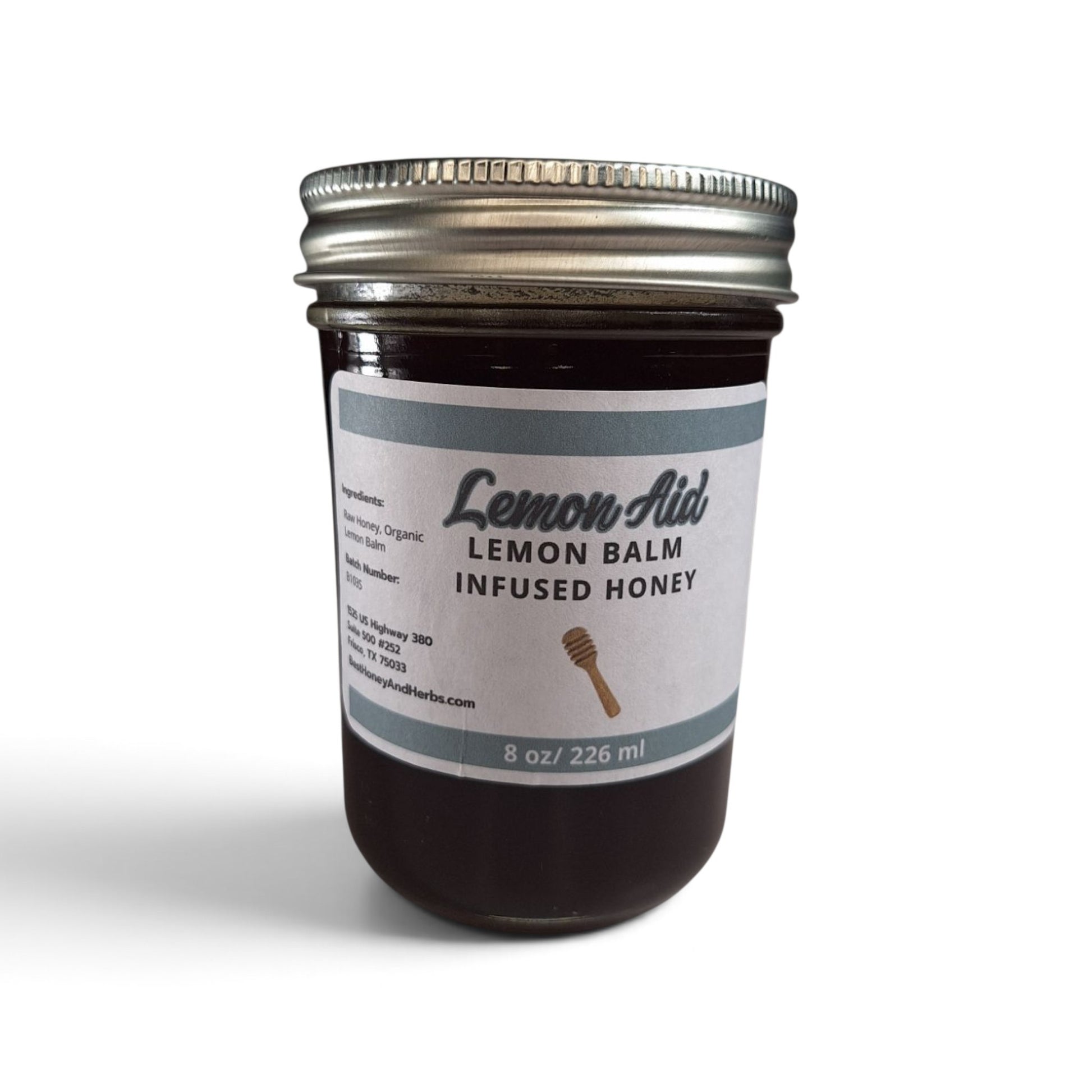 Raw honey infused with organic lemon balm in a glass jar with a metal lid.