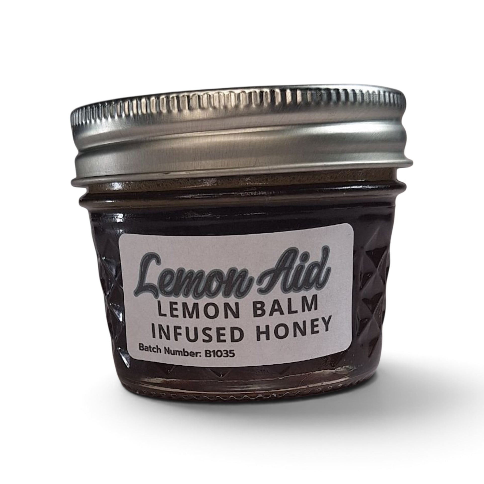 Raw honey infused with organic lemon balm in a quarter pint glass jar with a metal lid.
