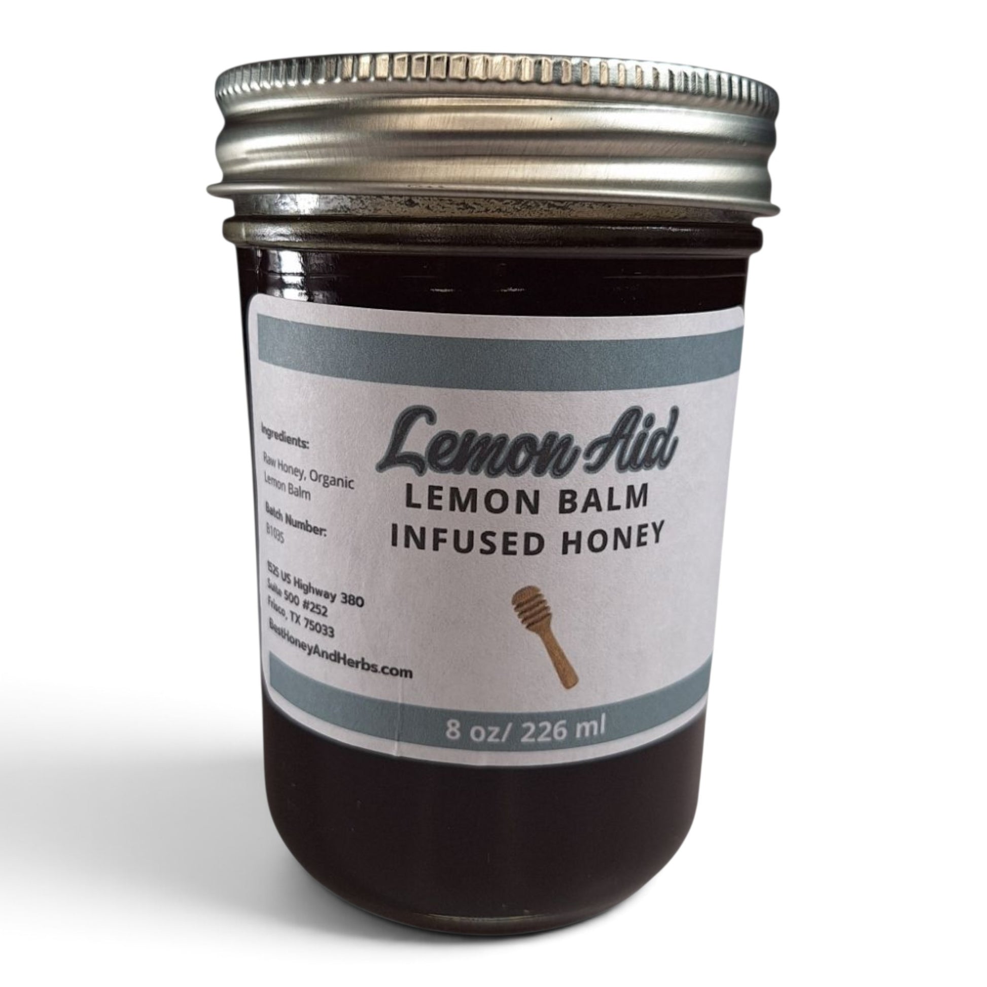 Raw honey infused with organic lemon balm in a glass jar with a metal lid.