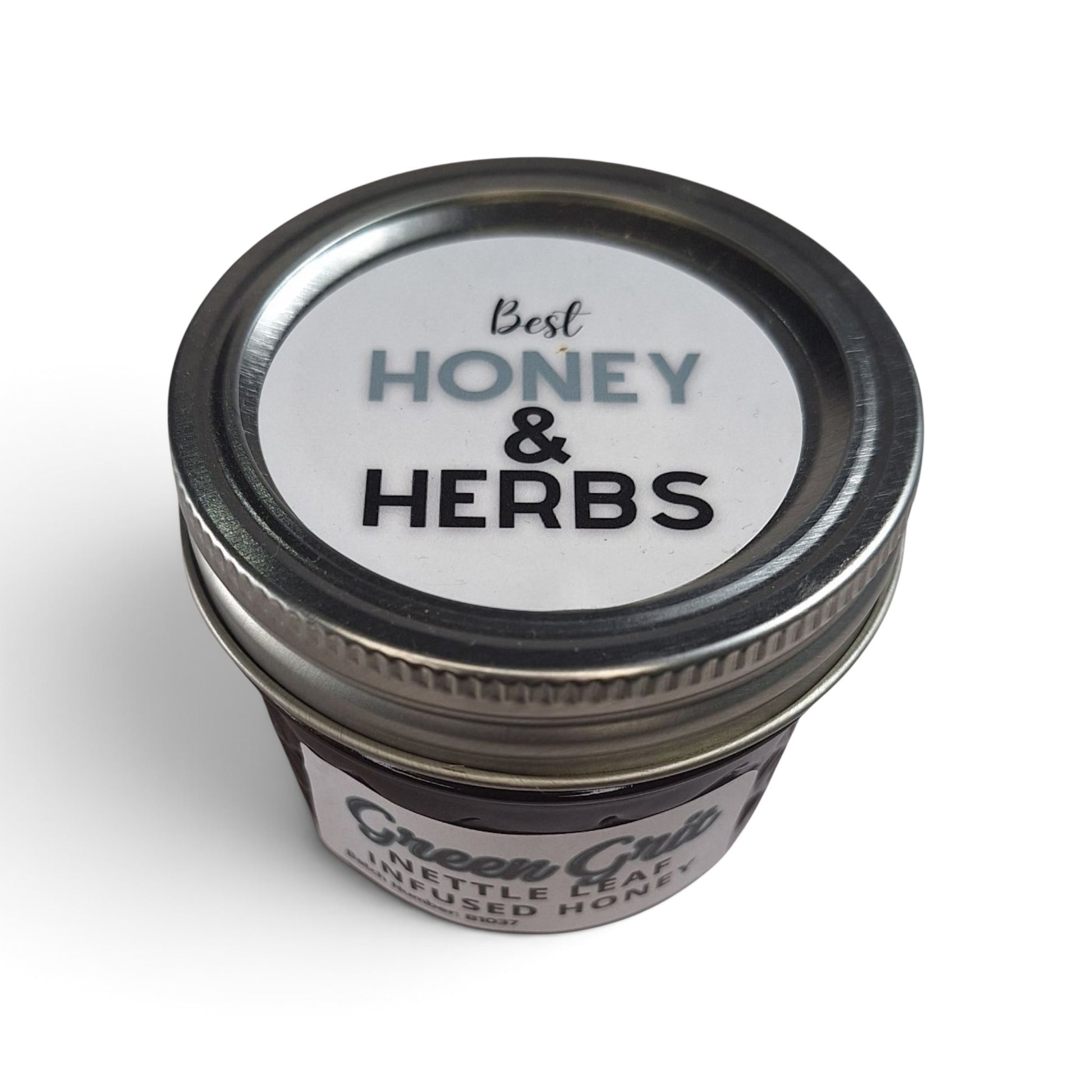 Nettle leaf infused raw honey in a small glass jar with a metal lid.