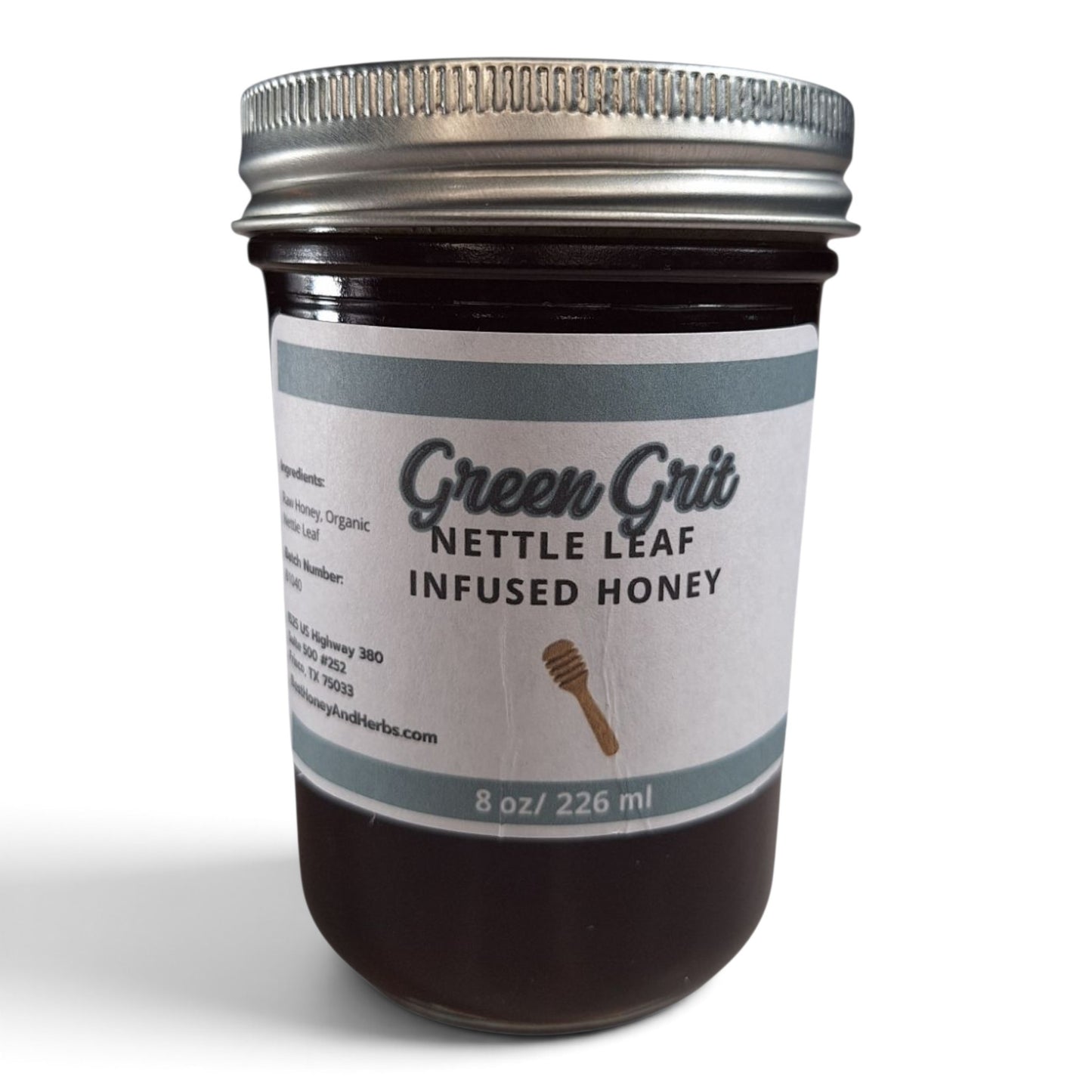 Nettle leaf infused raw honey in a glass jar with a metal lid.
