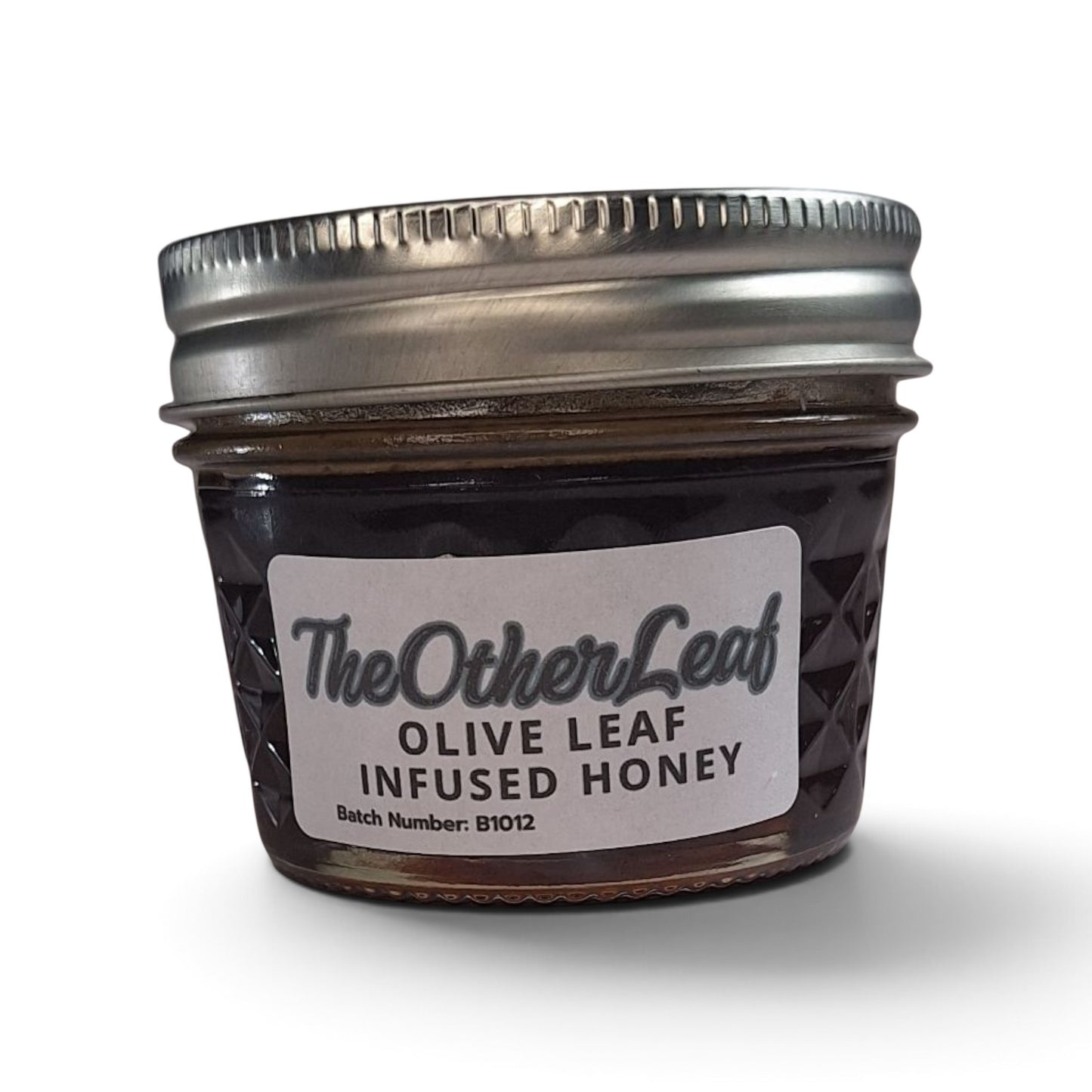  Olive leaf-infused raw honey in a quarter pint glass jar with a metal lid.