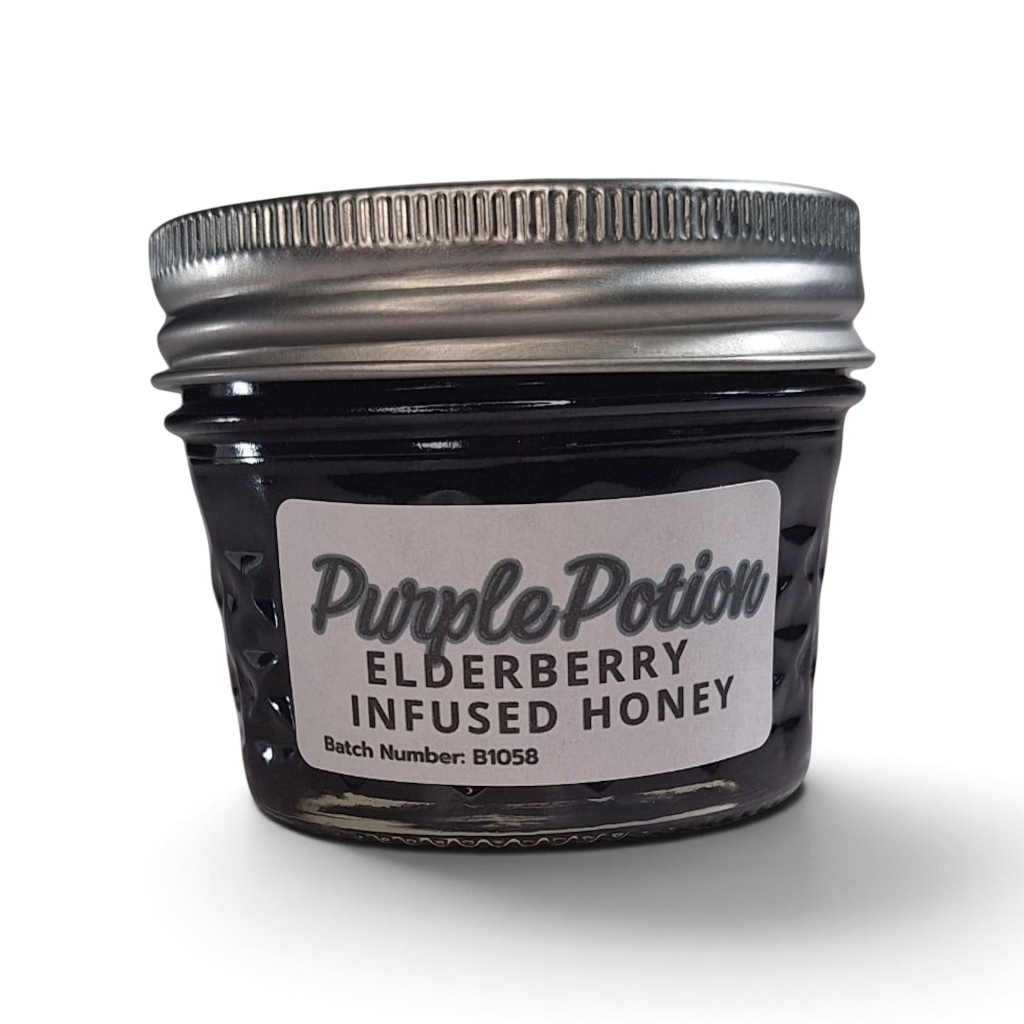  Elderberry infused raw honey in a small glass jar with a silver lid.