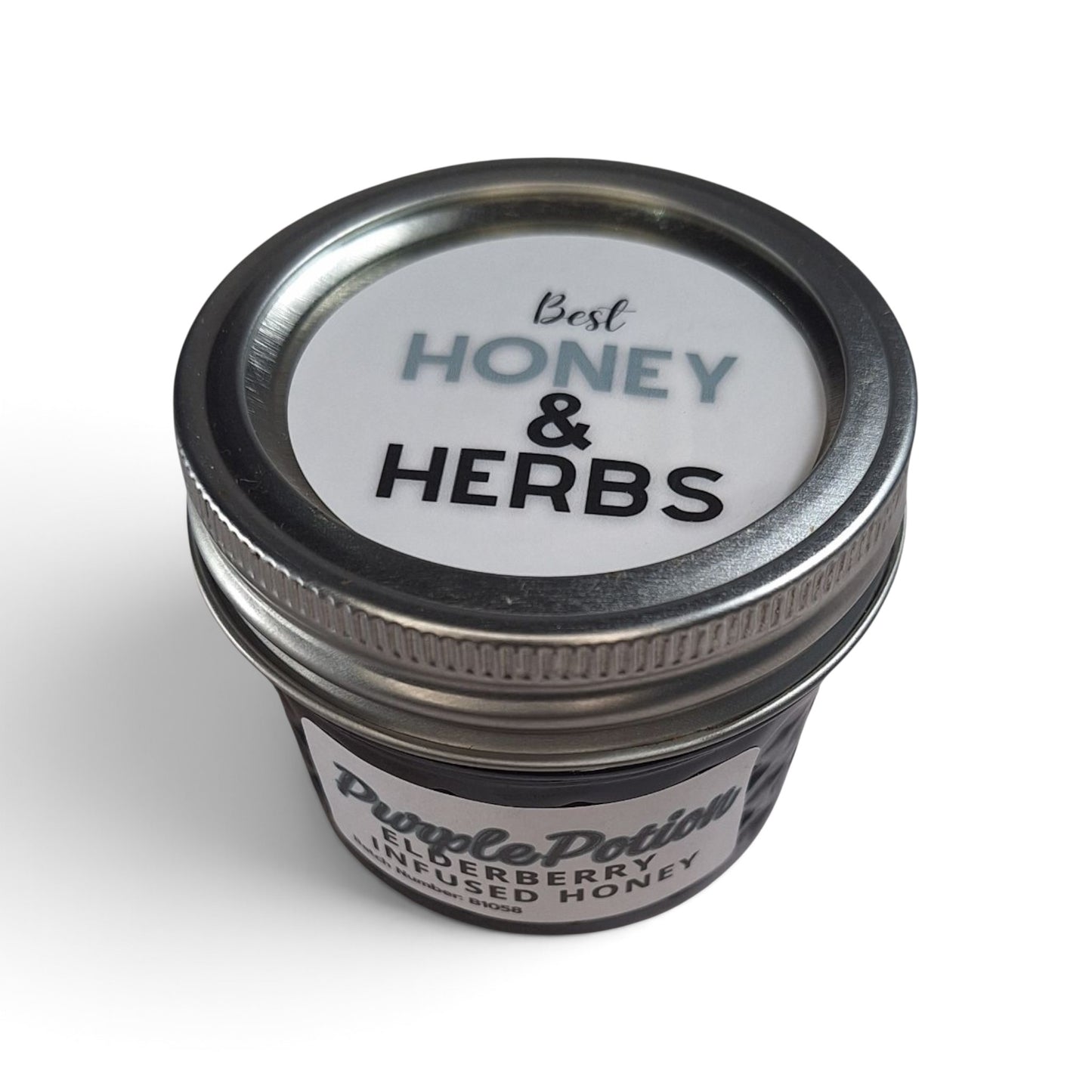  Elderberry infused raw honey in a small, quarter pint  jar with a silver metal lid.