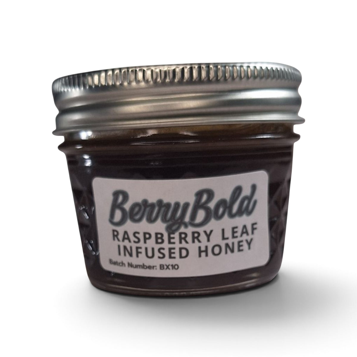 Raw honey infused with organic raspberry leaf in a small glass jar with metal lid.