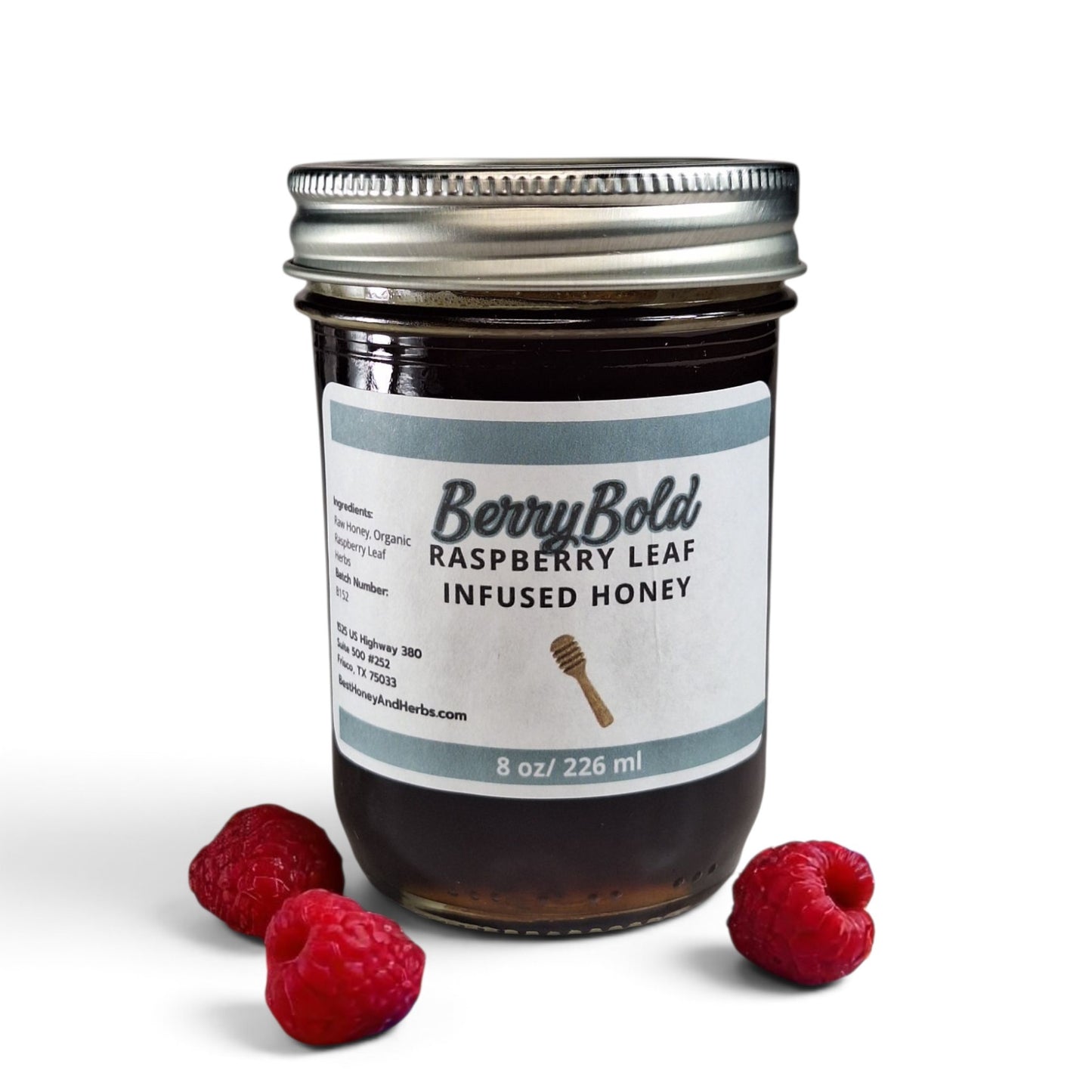 Raw honey infused with organic raspberry leaf in a glass jar with fresh raspberries surrounding jar.