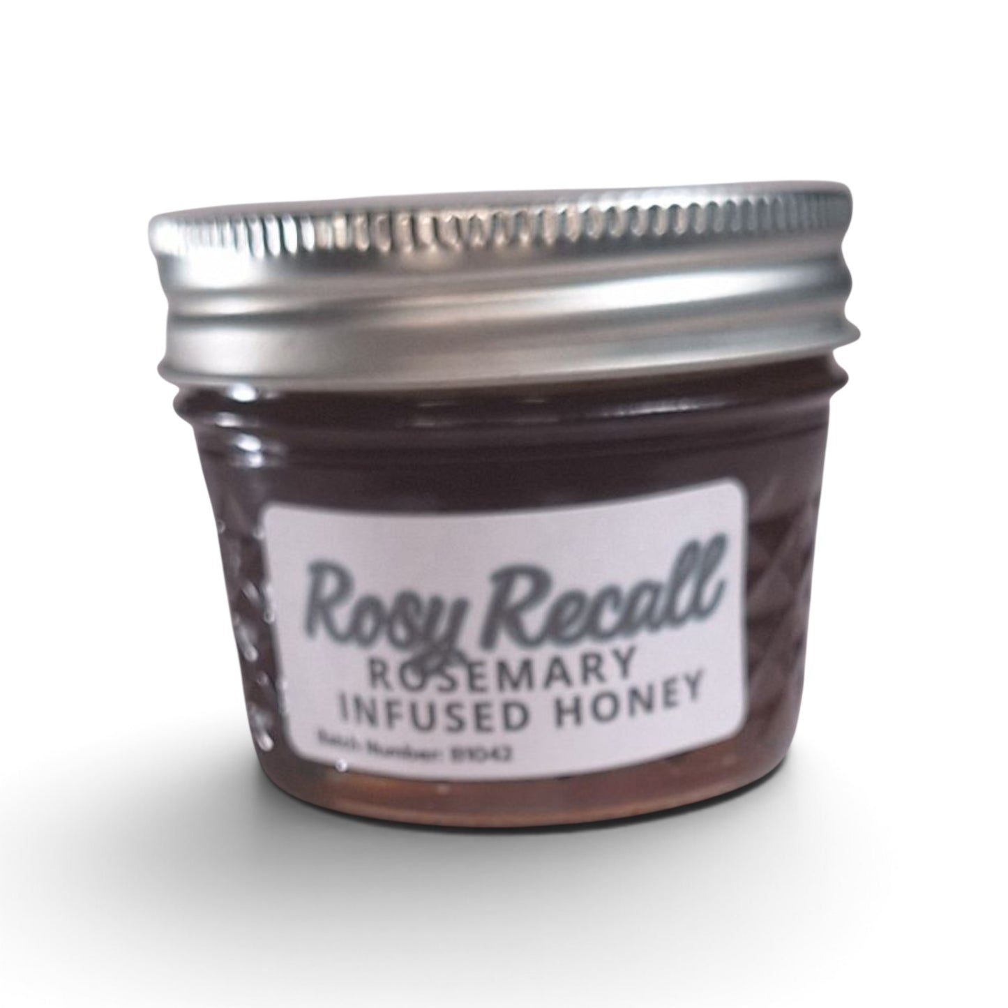  Rosemary infused raw honey in a quarter pint glass jar with a silver metal lid.