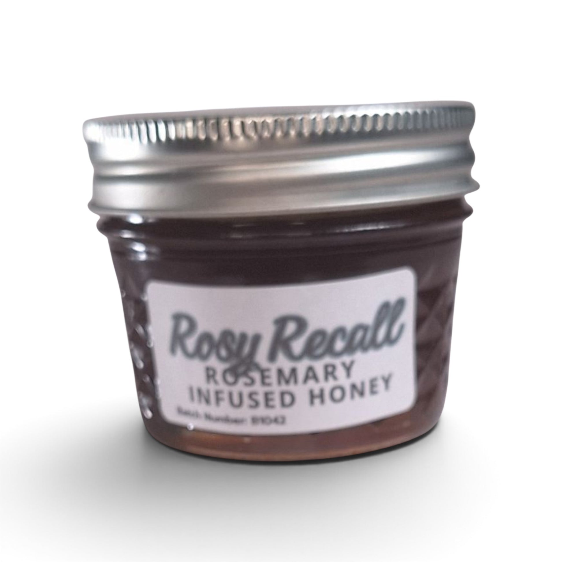  Rosemary infused raw honey in a quarter pint glass jar with a silver metal lid.