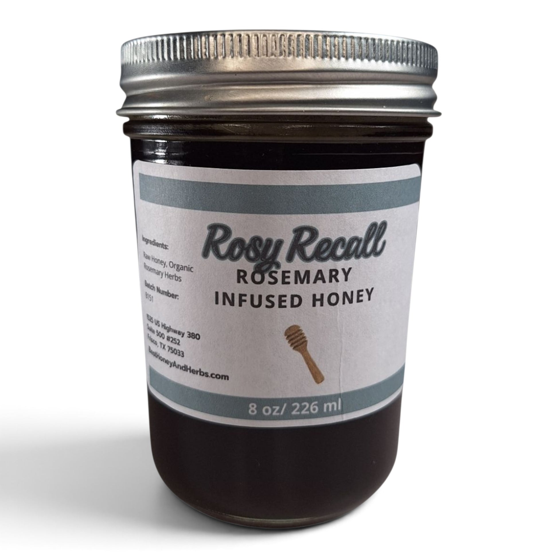 Rosemary infused raw honey in a half pint mason jar with a silver metal lid.