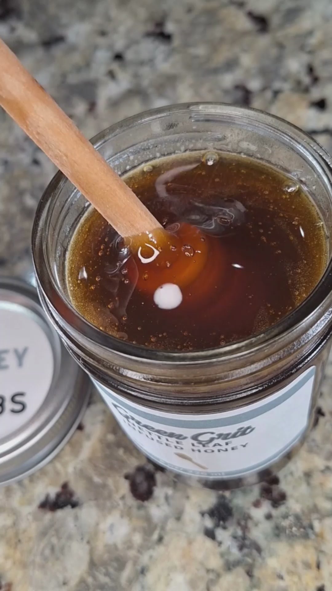  Nettle leaf infused honey slowly drizzling from a honey dipper.