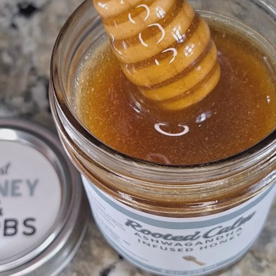 Ashwagandha infused raw honey slowly drizzling from a honey dipper, showing its smooth, golden texture,