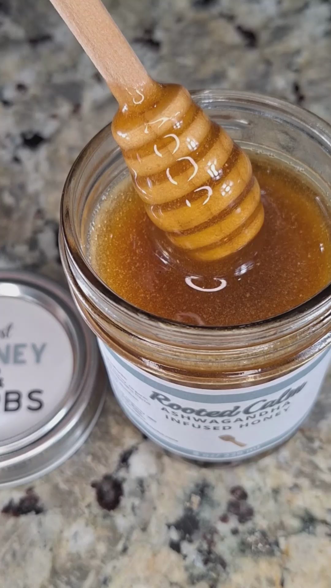 Ashwagandha infused raw honey slowly drizzling from a honey dipper, showing its smooth, golden texture,