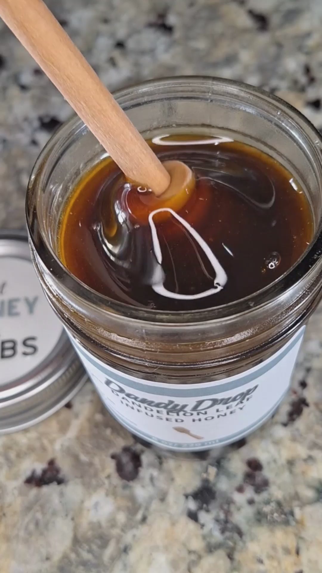  Dandelion Leaf infused honey slowly drizzling from a honey dipper.