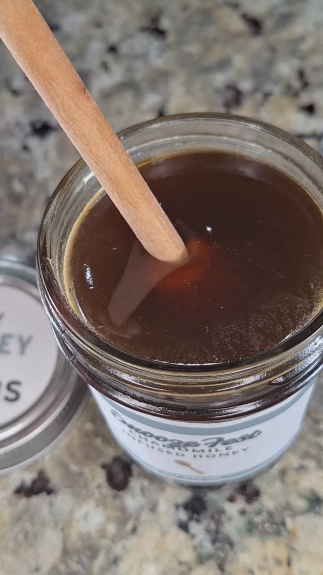 Chamomile infused honey slowly drizzling from a honey dipper.