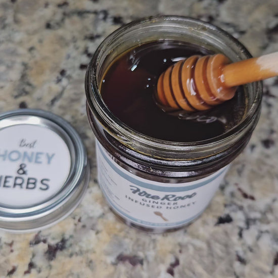 Ginger infused honey slowly drizzling from a honey dipper.