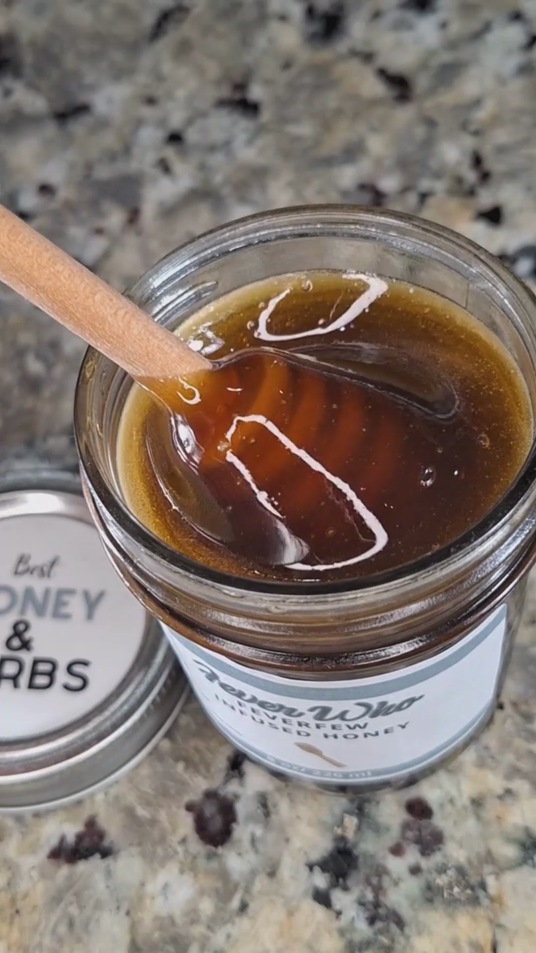 Feverfew infused honey slowly drizzling from a honey dipper.