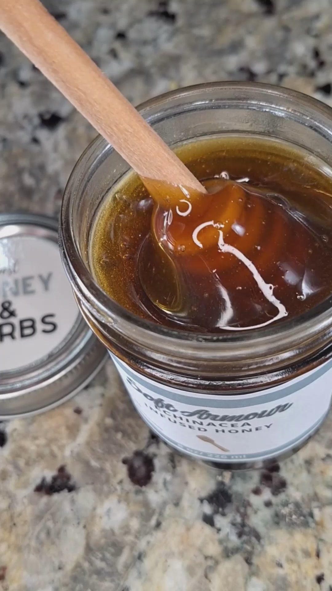  Echinacea infused honey slowly drizzling from a honey dipper.
