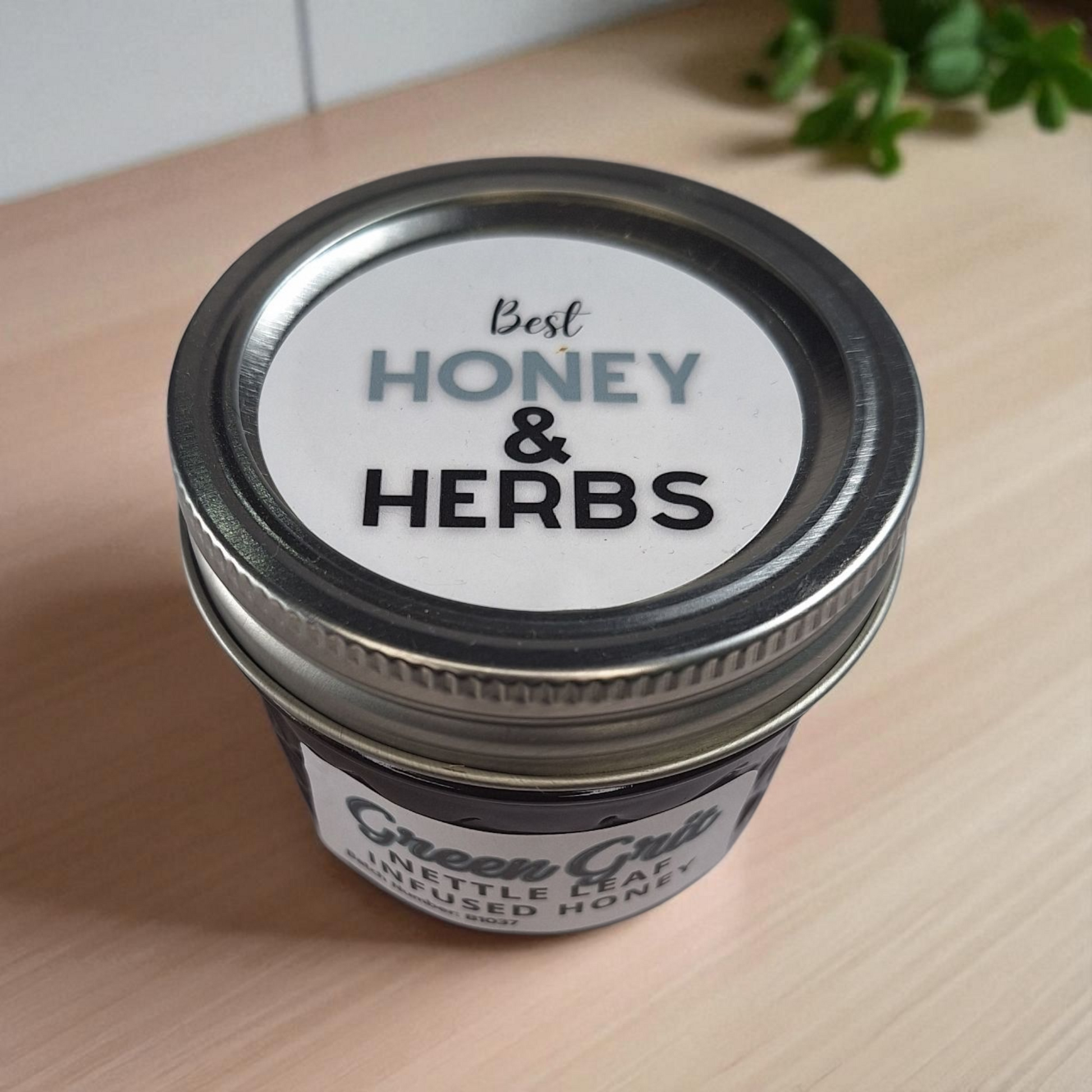 Bird’s-eye 4 oz Nettle Leaf Infused Honey on a wooden tabletop; earthy herbal honey for green teas and hearty breads.
