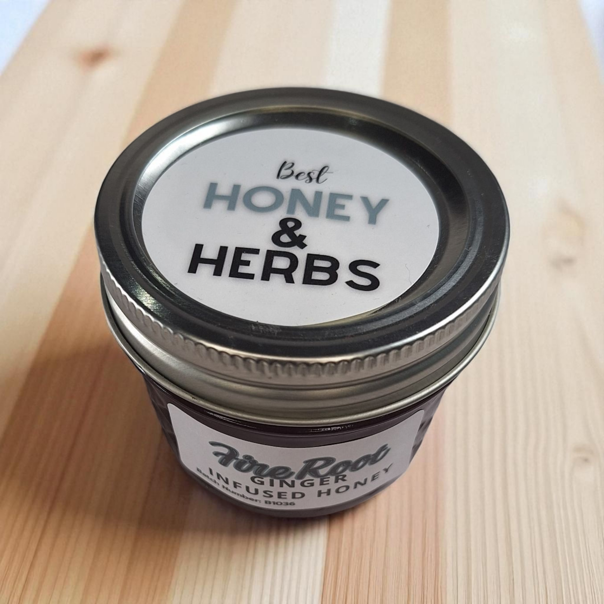 Overhead 4 oz Ginger Infused Honey on a wood board; zesty herbal sweetener for lemon tea, stir-fries, and marinades.